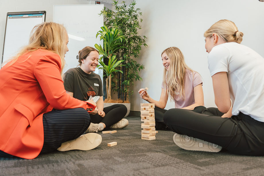 People sitting in a circle playing jenga